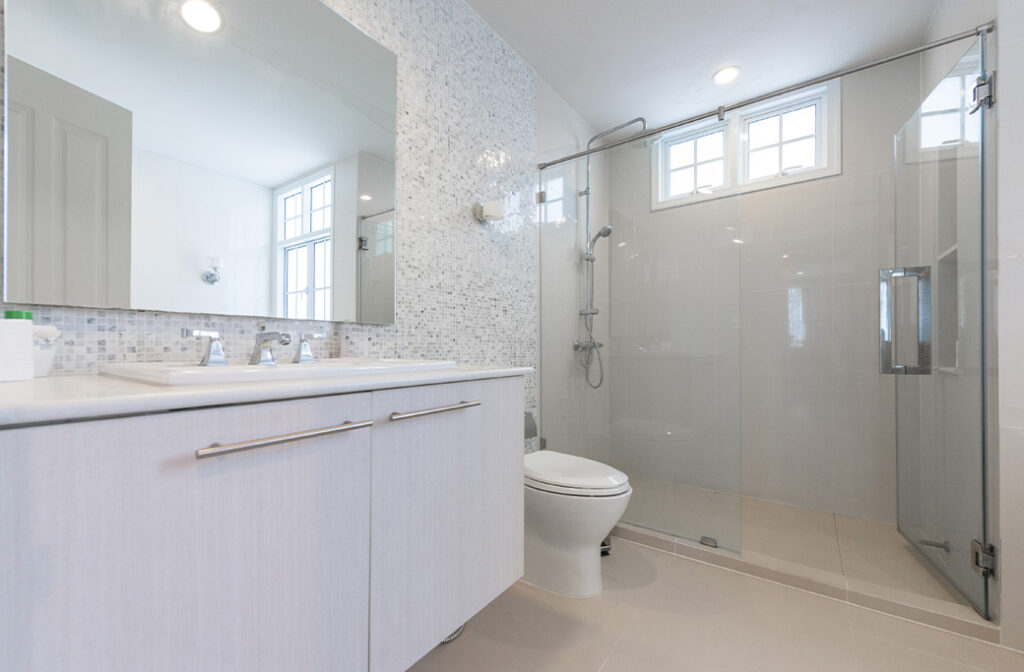 Modern walk-in shower with grab bars and accessible bathroom safety features.