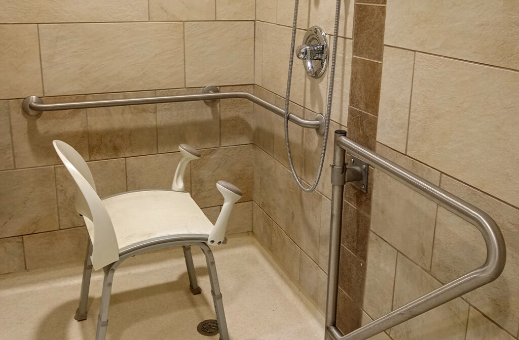 Modern curbless walk-in shower with built-in bench and stylish grab bars.